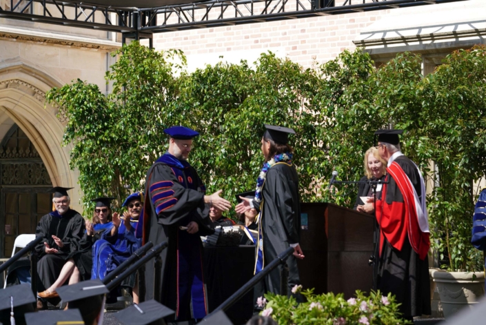 Professor Okin shaking a graduate's hand