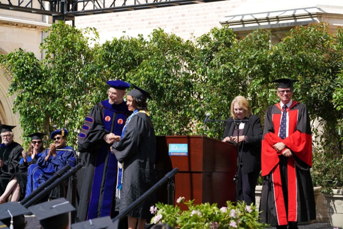 Professor Okin shaking a graduate's hand
